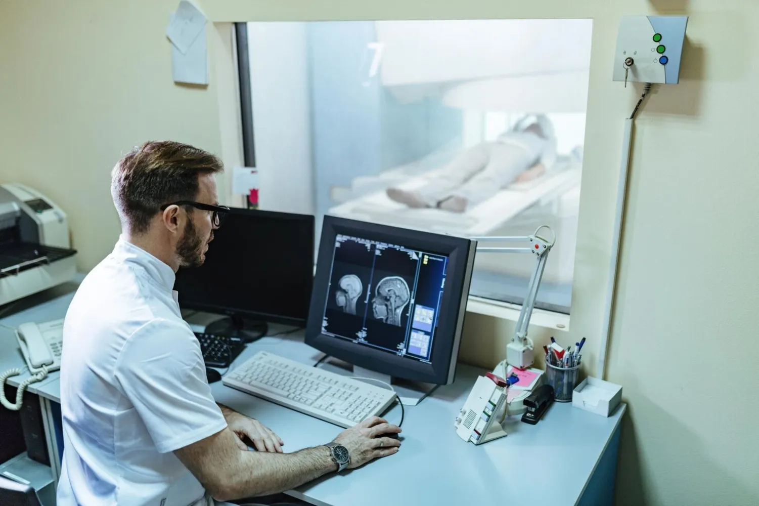 male radiologist analyzing mri scan results patient computer monitor control room 637285 5158 (1)